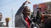 FILE - Former Haitian senator and presidential candidate Moise Jean Charles speaks to the press from a vehicle at the Toussaint Louverture International Airport in Port-au-Prince, Haiti, Jan. 25, 2022.