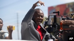 FILE - Former Haitian senator and presidential candidate Moise Jean Charles speaks to the press from a vehicle at the Toussaint Louverture International Airport in Port-au-Prince, Haiti, Jan. 25, 2022.