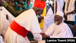 Le cardinal Philipe Ouédraogo, archevêque de Ouagadougou allant saluer l’iman après la prière de Ramadan, Ouagadougou, le 13 mai 2021. (VOA/Lamine Traoré)