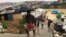 Rohingya refugees walks along the refugee camp during rain in Cox’s Bazar, Bangladesh, July 25, 2018.