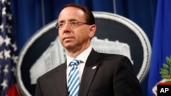 Deputy Attorney General Rod Rosenstein listens was Attorney General William Barr speaks about the release of a redacted version of special counsel Robert Mueller's report during a news conference, April 18, 2019, at the Department of Justice in Washington.