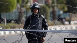 警察守卫在一所警官学院外，这里是被废除的埃及总统穆尔西及其穆斯林兄弟会成员2月1日计划受审的地点。