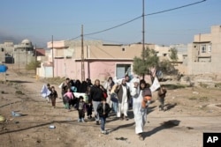 People displaced by fighting between the Iraqi military and Islamic State militants pass through an alley in Gogjali, on the eastern outskirts of Mosul, Iraq, Nov. 5, 2016. Mosul is the last major IS stronghold in Iraq.