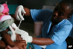 FILE - A child is vaccinated during a malaria vaccine trial in Bagamoyo, Tanzania in August 2007.