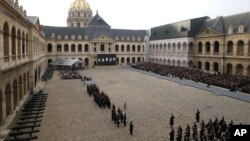 Guests, right, attend during a ceremony in the courtyard of the Invalides in Paris, Nov. 27, 2015.