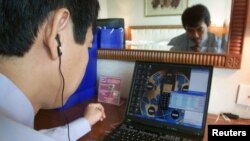 FILE - Tran Huynh Duy Thuc, founder of a Vietnamese Internet provider, makes a telephone call via the Internet in his office in Hanoi, July 3, 2003.Ho Chi Minh City is quickly becoming a destination for “tech nomads” – online entrepreneurs looking to take