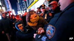 Police arrests protesters rallying against a grand jury's decision not to indict the police officer involved in the death of Eric Garner attempted to block traffic at the intersection of 42nd Street and Seventh Avenue near Times Square, Thursday, Dec. 4, 2014, in New York. (AP Photo/Jason DeCrow)