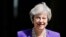 La première ministre britannique, Theresa May, quitte le 10 Downing Street à Londres avant la session hebdomadaire des questions à la Chambre des communes, le 4 juillet 2018.