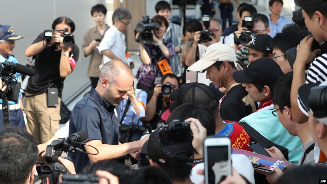 Bintang sepak bola Spanyol, Andres Iniesta (tengah kiri) memberikan tanda tangan pada saat disambut oleh pendukung klub Vissel Kobe di Bandara Internasional Kansai di Osaka, Rabu, 18 Juli 2018.