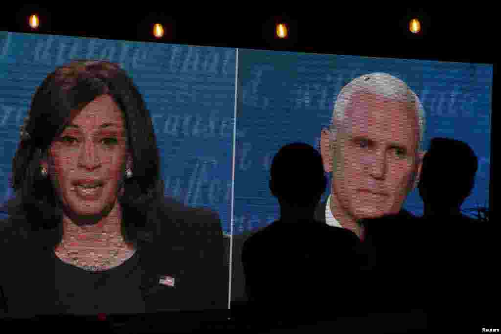 Un par de personas observan el debate entre Mike Pence y Kamala Harris, fuera de una taberna en San Diego, California, Estados Unidos, el 7 de octubre de 2020.