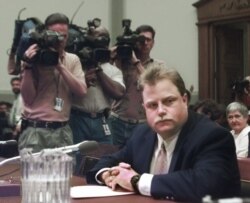 FILE - Photographers surround Richard Jewell prior to his testifying before a House Judiciary Crime subcommittee hearing, July 30, 1997, on the Olympic bombing in Atlanta.