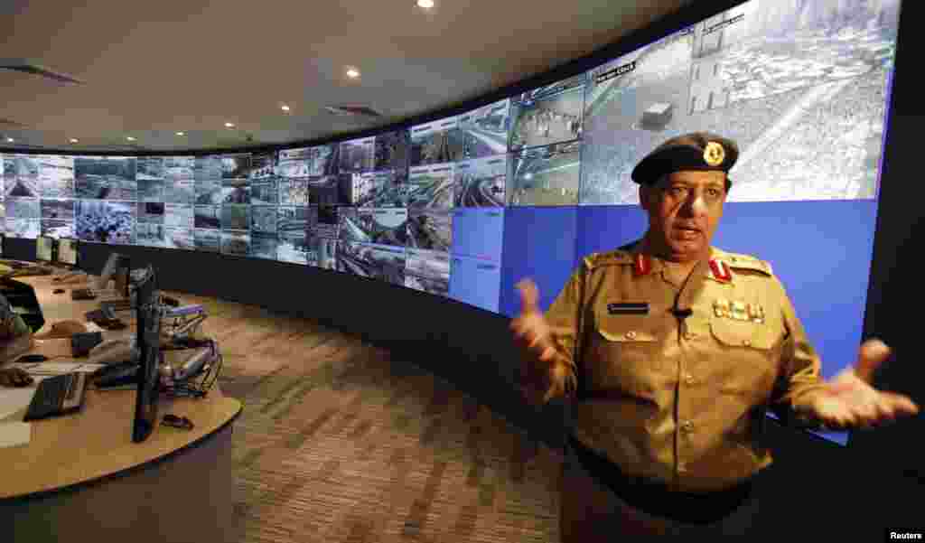 Saudi General Monitor policeman Khaled Al Amri talks about the monitor screens showing the footage from cameras set up around the holy places, on the second day of Eid al-Adha, in the holy city of Mecca October 27