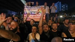 Участники акции протеста против гей-прайда в Тбилиси держат в руках плакат с изображением Келли Дегнан, посла США в Грузии