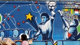 FILE - A resident stands near a mural depicting the famous 