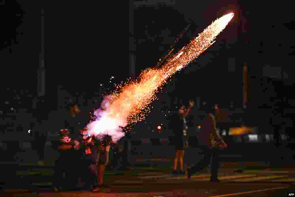 Protesters set off fireworks as they take part in a demonstration in Bangkok, calling for the resignation of Thailand&#39;s Prime Minister Prayut Chan-O-Cha over the government&#39;s handling of the Covid-19 coronavirus crisis.