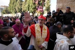 Latin Patriarch Pierbattista Pizzaballa, the top Catholic clergyman in the Holy Land, waves as he arrives at the Church of the Nativity on Christmas Eve in the West Bank city of Bethlehem, Dec. 24, 2024.