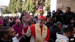 Latin Patriarch Pierbattista Pizzaballa, the top Catholic clergyman in the Holy Land, waves as he arrives at the Church of the Nativity, on Christmas Eve in the West Bank city of Bethlehem, Dec. 24, 2024.