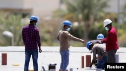 Workers wearing protective face masks work on a residential construction site, following the outbreak of coronavirus disease (COVID-19), in Dubai, United Arab Emirates, April 14, 2020.