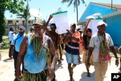 Sejumlah pria membawa kotak suara di Buka, Bougainville, Papua Nugini. (Foto: AP)