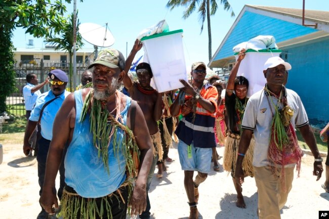 Sejumlah pria membawa kotak suara di Buka, Bougainville, Papua Nugini. (Foto: AP)
