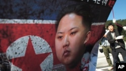 FILE - North Korean defector Park Sang Hak, right, carries a poster showing North Korean leader Kim Jong-Un during an anti-North Korea rally near the Unification Observation Post in Paju, South Korea