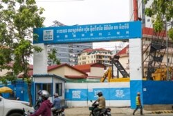 FILE - Travelers drive pass a Chinese construction site in the center of Phnom Penh's Boeung Keng Kang district, May 9, 2019. (Sun Narin/VOA Khmer)