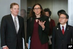 EU Commissioner for Trade Cecilia Malmstroem, center, Japanese Minister for Economy, Trade and Industry Hiroshige Seko, right, and US Trade Representative Robert Lighthizer, pose for photographers prior to a meeting at EU headquarters in Brussels, March 10, 2018.