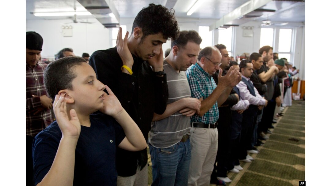 Men and children attend a prayer service at Masjid Al-Farooq for the Muslim holiday of Eid al-Fitr, June 15, 2018, in the Brooklyn borough of New York.