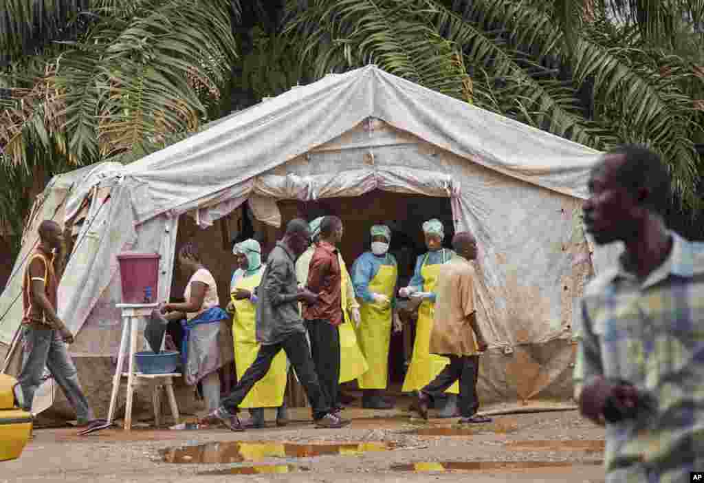 Health workers prescreen people for the deadly Ebola virus before they enter the Kenema Government Hospital in Kenema, Sierra Leone, August 9, 2014.