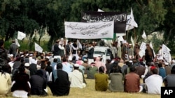 FILE - Nangarhar University students gather as some raise Taliban and Islamic State flags in Jalalabad, Afghanistan, Nov. 8, 2015. An Afghan official said the government is investigating links between universities and extremist groups.
