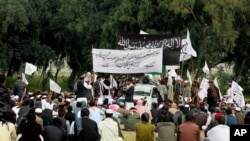 FILE - Nangarhar University students gather as some raise Taliban and Islamic State flags in Jalalabad, Afghanistan, Nov. 8, 2015.