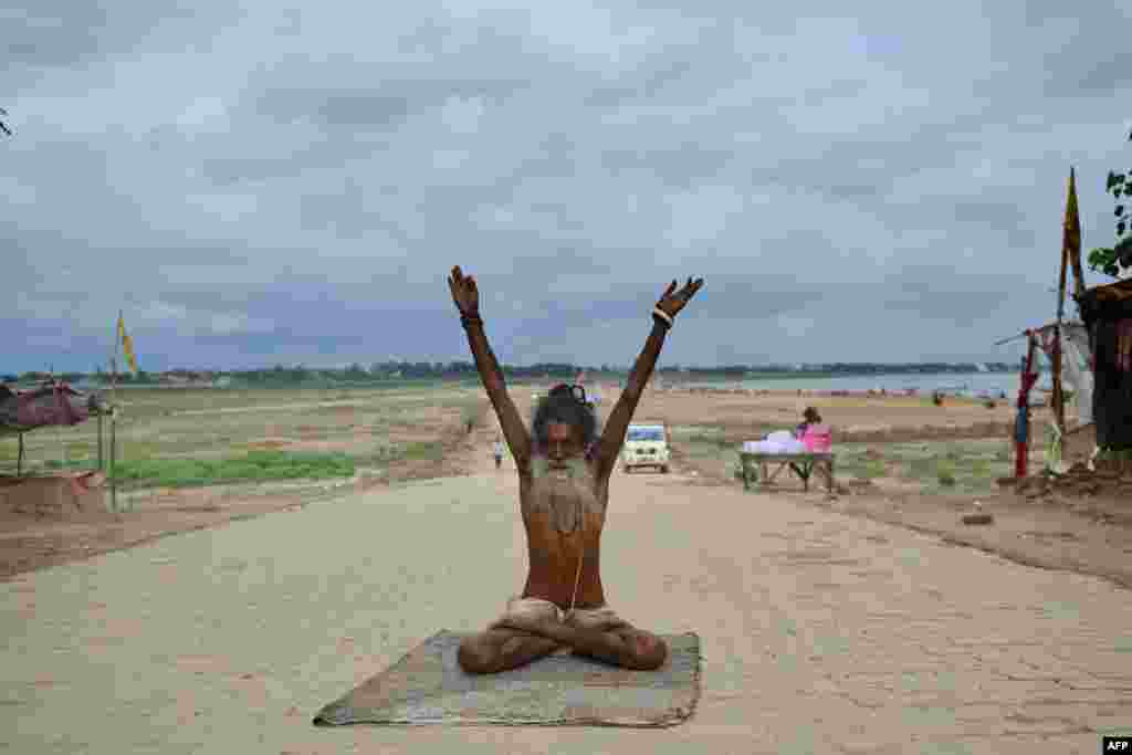 A Sadhu (holy man) performs yoga at the Sangam, the confluence of the rivers Ganges and Yamuna and mythical Saraswati, in Allahabad, India, June 20, 2020.