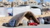 A displaced Palestinian girl sits under a mattress as waits to flee Hamad City with her family following an Israeli evacuation order, in Khan Younis in the southern Gaza Strip, Aug. 11, 2024. 