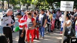 Cubanos esperan por visas en la Oficina de Intereses Estadounidenses en La Habana.