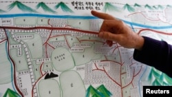 A United Nations Human Rights staff points to the title of a drawing describing North Korean labour camp no 18, a gift made in December 2012 by survivor Kim Hye Sook, in Geneva February 17, 2014. 