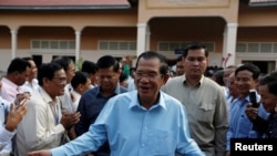 Perdana Menteri Kamboja dan Presiden Partai Rakyat Kamboja (CPP), Hun Sen dikelilingi oleh para konselor komunalnya saat pemilihan Senat di Takhmao, provinsi Kandal, Kamboja, 25 Februari 2018.