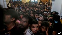 معترضان در سریلانکا پس از اظهارات نخست وزیر که اقتصاد کشورش زیر بار بدهی‌ها متلاشی شده است به ساختمان نخست وزیری هجوم بردند و خواستار استعفای او شدند. ۱۳ ژوئیه ۲۰۲۲. آسوشیتدپرس. 