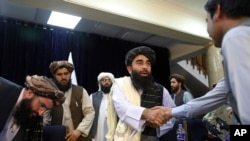 Msemaji wa utawala wa Taliban Zabihullah Mujahid akisaliana na mwandishi wa habari baada ya kuhutubia waandishi wa habari mjini Kabul Aug 17, 2021