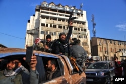 Pemberontak Suriah merayakan kemenangan di sekitar Menara Jam di Homs pada 8 Desember 2024, setelah berhasil memasuki kota terbesar ketiga di Suriah pada malam sebelumnya. (Foto: AFP)