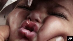 FILE - a Pakistani medic gives a polio vaccine to a child in Peshawar, Pakistan.