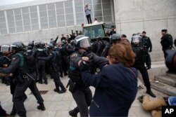 Civil guards clear people away from the entrance of a sports center, assigned to be a polling station by the Catalan government in Sant Julia de Ramis, near Girona, Spain, Oct. 1, 2017.