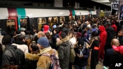 Commuters wait to catch a subway train Tuesday, Dec. 10, 2019 in Paris. Only about a fifth of French trains ran normally Tuesday, frustrating tourists finding empty train stations, and most Paris subways were at a halt. French airport workers,…