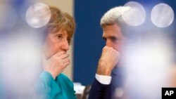 El secretario de Estado, John Kerry (derecha) conversa con la representante de la UE, Catherine Ashton, durante una reunión de la OTAN en Bruselas.