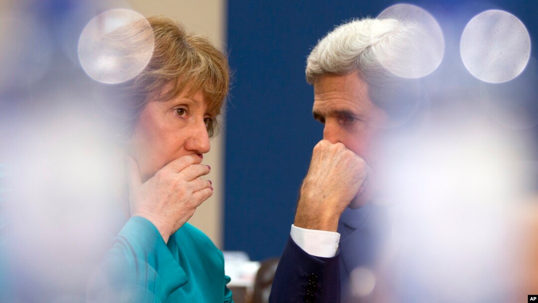El secretario de Estado, John Kerry (derecha) conversa con la representante de la UE, Catherine Ashton, durante una reunión de la OTAN en Bruselas.