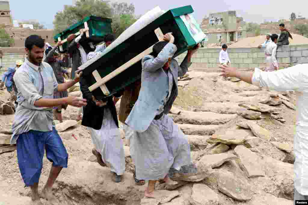 Mourners carry coffins during a funeral of people, mainly children, killed in a Saudi-led coalition airstrike on a bus in Saada, Yemen. Aug. 13, 2018.
