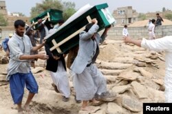 FILE - Mourners carry coffins during a funeral of people, mainly children, killed in a Saudi-led coalition airstrike on a bus in Saada, Yemen, Aug. 13, 2018.