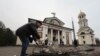 FILE - A man clears the rubble in front of St. Andrew's Cathedral which was damaged by a Russian strike on Zaporizhzhia, Ukraine, Jan 18, 2025.