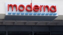 A man stands outside an entrance to a Moderna, Inc., building, May 18, 2020, in Cambridge, Mass. Moderna announced Monday that an experimental vaccine against the coronavirus showed encouraging results in very early testing.