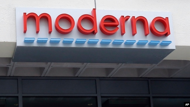 A man stands outside an entrance to a Moderna, Inc., building, May 18, 2020, in Cambridge, Mass. Moderna announced Monday that an experimental vaccine against the coronavirus showed encouraging results in very early testing.