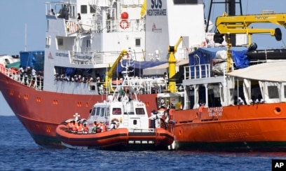 An Italian Coast Guard boat approaches the Aquarius ship as migrants are being transferred, in the Mediterranean Sea, June 12, 2018.